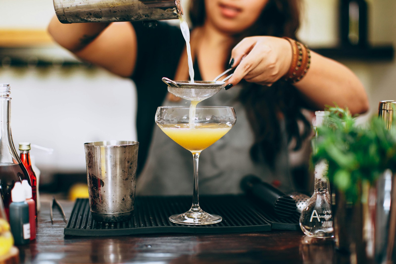 woman in black sleeveless top holding clear cocktail glass